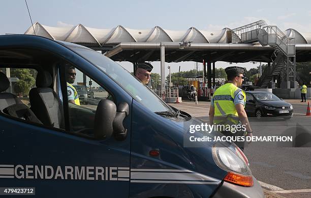 French police officers from the gendarmerie control traffic at a motorway tollbooth in Fleury-en-Bière on July 4, 2015. The number of deaths on roads...