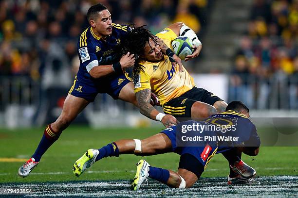 Ma'a Nonu of the Hurricanes is tackled by Aaron Smith and Lima Sopoaga of the Highlanders during the Super Rugby Final match between the Hurricanes...
