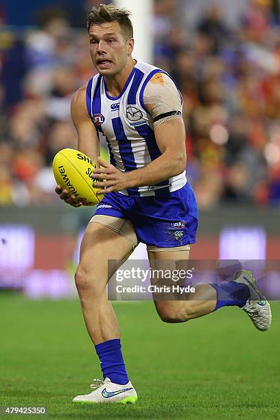 Shaun Higgins of the Kangaroos runs the ball during the round 14 AFL match between the Gold Coast Suns and the North Melbourne Kangaroos at Metricon...