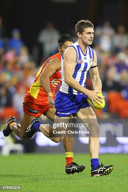 Shaun Atley of the Kangaroos runs the ball during the round 14 AFL match between the Gold Coast Suns and the North Melbourne Kangaroos at Metricon...