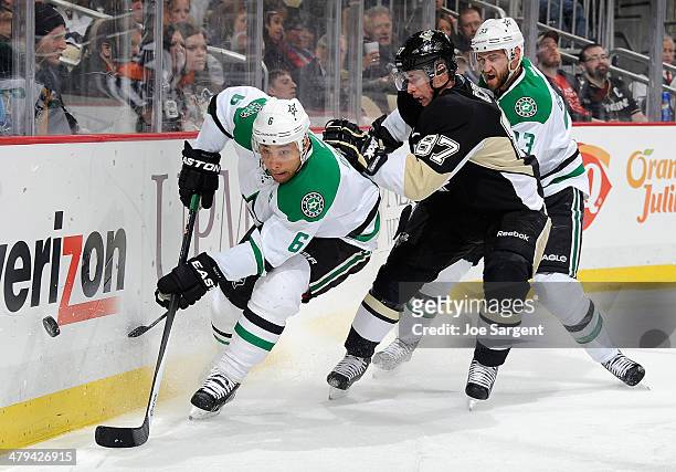 Sidney Crosby of the Pittsburgh Penguins battles for the loose puck between the defense of Trevor Daley and Alex Goligoski of the Dallas Stars on...