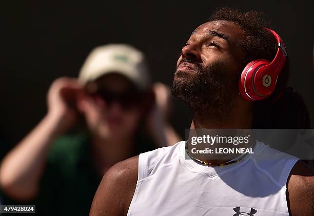 Germany's Dustin Brown sits with Beats by Dr. Dre headphones on ahead of his men's singles third round match against Serbia's Viktor Troicki on day...