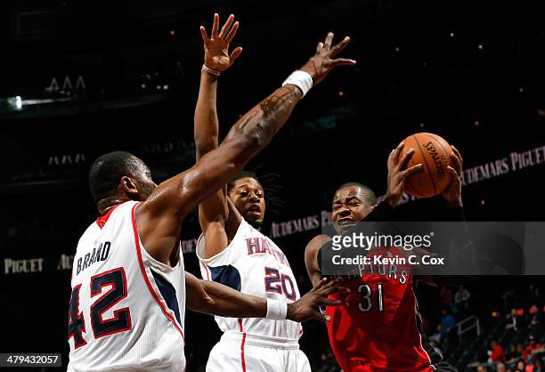 Elton Brand and Cartier Martin of the Atlanta Hawks defend against Terrence Ross of the Toronto Raptors at Philips Arena on March 18, 2014 in...