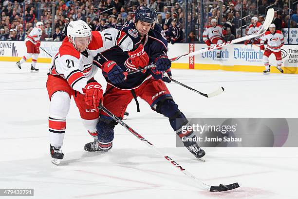 Drayson Bowman of the Carolina Hurricanes and Fedor Tyutin of the Columbus Blue Jackets battle for the puck during the second period on March 18,...