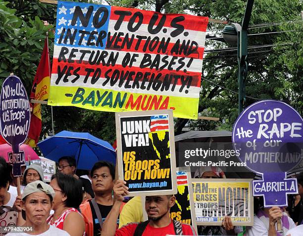 Filipino activists hold slogans during a rally at Plaza Salamanca coinciding with the Fourth of July Celebrations in the USA, which is also...