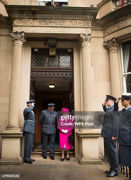 Queen Elizabeth II is accompanied by Commanding Officer Jerry Riley during a visit to the headquarters of the Royal Auxiliary Air Force's 603...