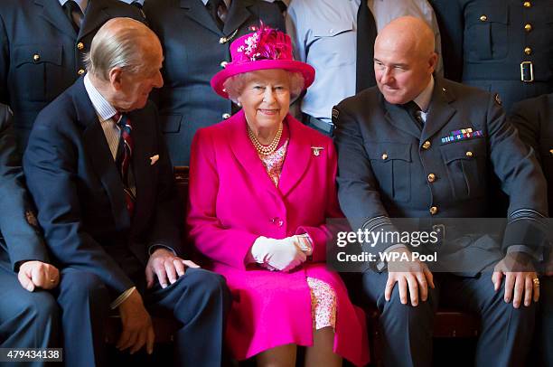 Prince Philip, Duke of Edinburgh, Queen Elizabeth II and Commanding Officer Jerry Riley pose with RAF members during a visit to the headquarters of...