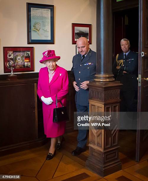 Queen Elizabeth II is accompanied by Commanding Officer Jerry Riley during a visit to the headquarters of the Royal Auxiliary Air Force's 603...