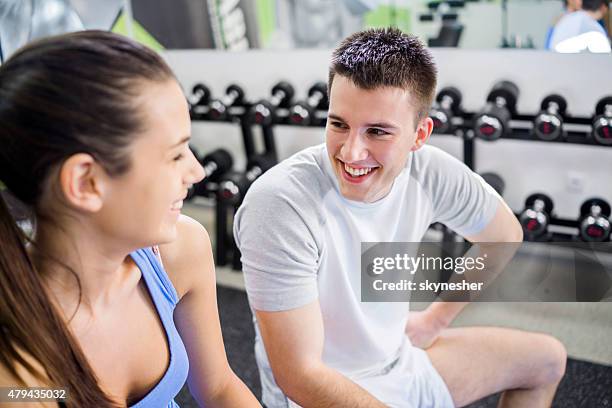 smiling couple communicating during a break in a gym. - flirting gym stock pictures, royalty-free photos & images