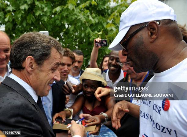 Former French president and president of French right-wing opposition party Les Republicains, Nicolas Sarkozy , sign autographs next to a supporter...