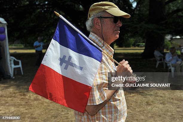 Man carries a French flag with the Cross of Lorraine during the third "Fete de la Violette" , a political gathering organised by "La Droite Forte" ,...