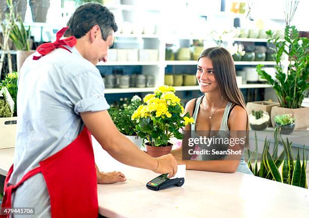 pago con tarjeta de crédito en la floristería - tarjeta inteligente fotografías e imágenes de stock