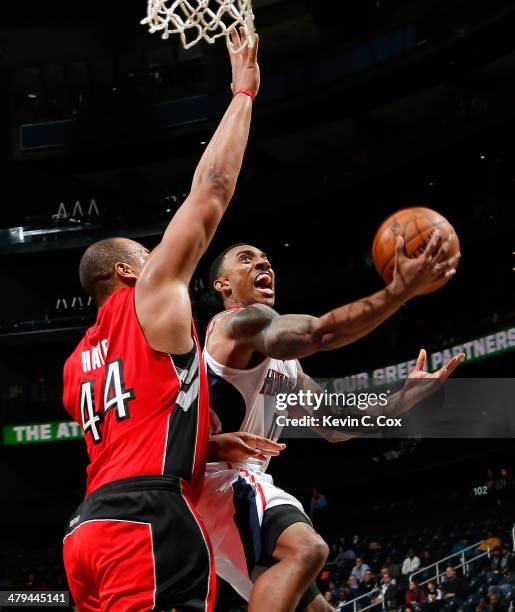 Jeff Teague of the Atlanta Hawks shoots against Chuck Hayes of the Toronto Raptors at Philips Arena on March 18, 2014 in Atlanta, Georgia. NOTE TO...