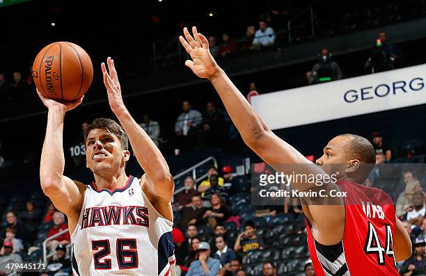 Kyle Korver of the Atlanta Hawks shoots against Chuck Hayes of the Toronto Raptors at Philips Arena on March 18, 2014 in Atlanta, Georgia. NOTE TO...