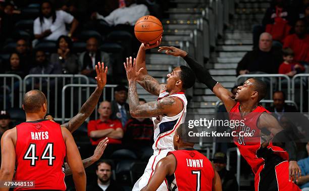 Jeff Teague of the Atlanta Hawks shoots against Chuck Hayes, John Salmons, Kyle Lowry and Terrence Ross of the Toronto Raptors at Philips Arena on...