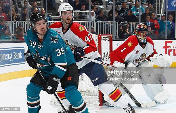 Logan Couture of the San Jose Sharks gets in position for a pass against Colby Robak and Roberto Luongo of the Florida Panthers during an NHL game on...