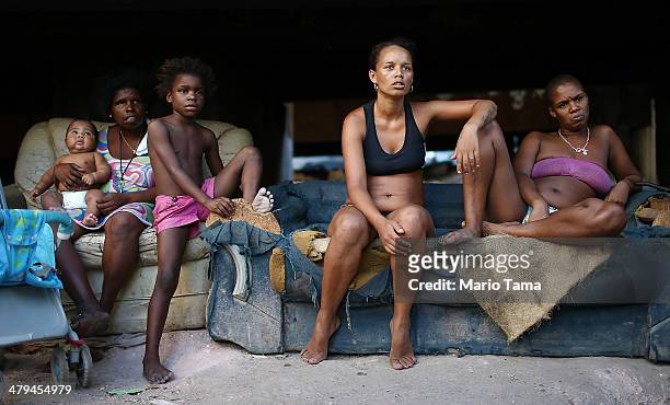 Residents Luiza, Janubie, Leiticia, Anacleide and Lucas sit beneath an overpass near their houses in an impoverished area in the unpacified Complexo...