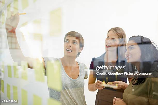 die idee zimmer - team looking at adhesive notes in board room during meeting stock-fotos und bilder
