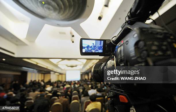 Spokesman for Malaysia Airlines is displayed on a screen of media camera as he speaks with relatives of passengers from missing Malaysia Airlines...