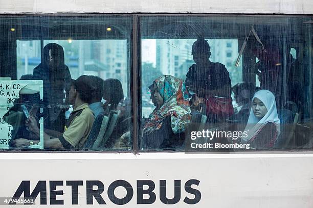 Passengers sit in a bus operated by Metrobus Nationwide Sdn. Bhd. In Kuala Lumpur, Malaysia, on Tuesday, March 18, 2014. Malaysia, aspiring to become...