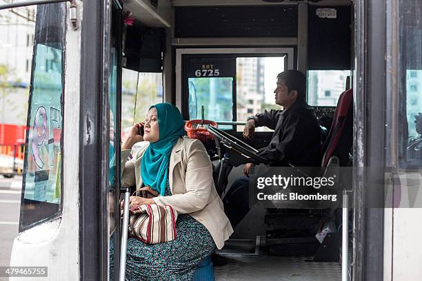 Commuter sits in a bus operated by Metrobus Nationwide Sdn. Bhd. While waiting for the bus to depart in Kuala Lumpur, Malaysia, on Tuesday, March 18,...