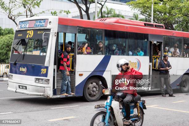 The conductor of a bus operated by Rapid Bus Sdn. Bhd. Calls for passengers in Kuala Lumpur, Malaysia, on Tuesday, March 18, 2014. Malaysia, aspiring...