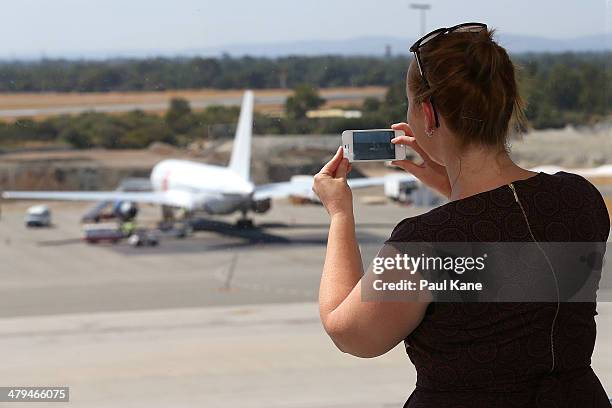Journalist takes a photo on her smartphone of the Aeronexus Corporation's - Boeing 767 used by the Rolling Stones at Perth international airport on...