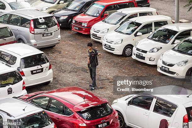 Parking attendant directs cars in a makeshift parking lot during the morning rush hour in Kuala Lumpur, Malaysia, on Tuesday, March 18, 2014....