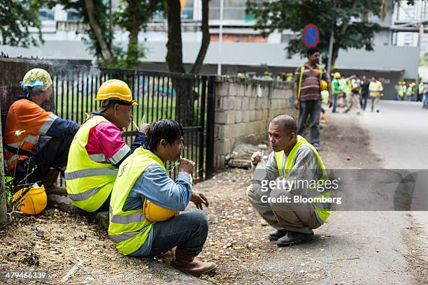 Construction workers from the Philippines take a break in Kuala Lumpur, Malaysia, on Tuesday, March 18, 2014. Malaysia, aspiring to become a...