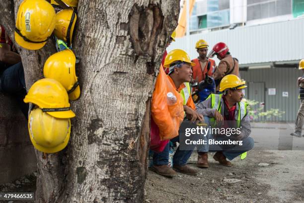 Construction workers take a break in Kuala Lumpur, Malaysia, on Tuesday, March 18, 2014. Malaysia, aspiring to become a developed nation in six...