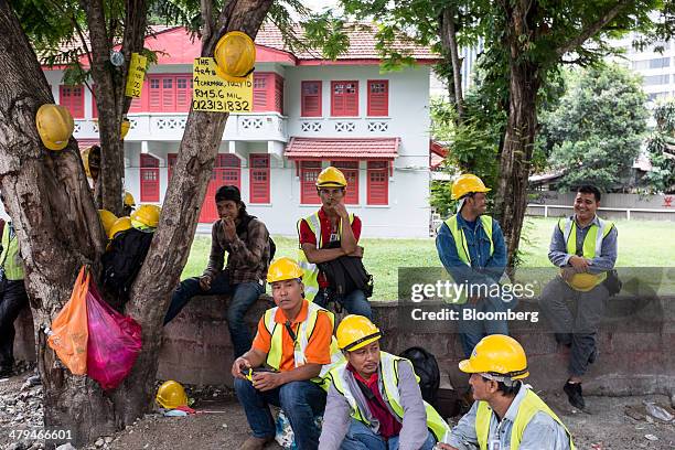 Construction workers take a break in Kuala Lumpur, Malaysia, on Tuesday, March 18, 2014. Malaysia, aspiring to become a developed nation in six...