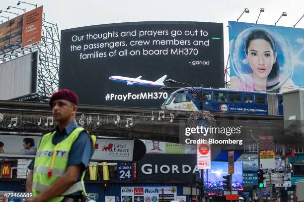 Billboard for missing Malaysian Airline System Bhd. Flight 370 is displayed in Kuala Lumpur, Malaysia, on Tuesday, March 18, 2014. Malaysia, aspiring...
