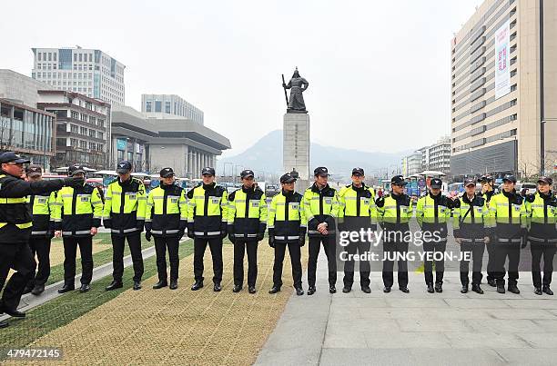 Policemen stand guard while South Korean conservative activists hold an anti-North Korea rally at Gwanghwamun plaza in Seoul on March 19, 2014. South...