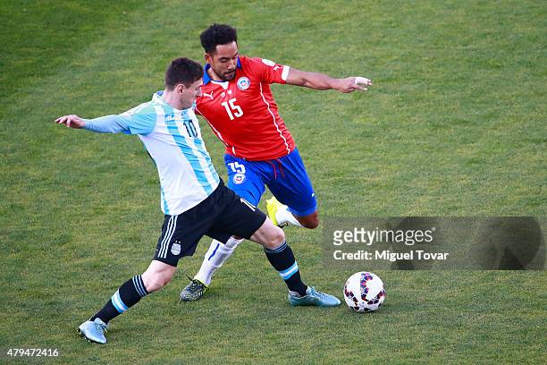 Lionel Messi of Argentina fights for the ball with Victor Caceres of Paraguay during the 2015 Copa America Chile Final match between Chile and...