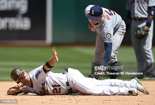Stephen Vogt of the Oakland Athletics calls timeout after he slides into second base with a double beatting the tag of Brad Miller of the Seattle...