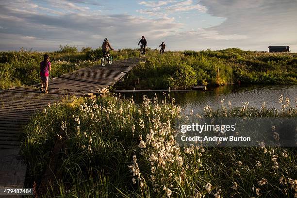 Yupik children ride their bikes late in the evening on July 3, 2015 in Newtok, Alaska. Newtok is one of several remote Alaskan villages that is being...