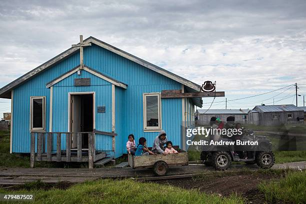 Jamin Tom takes his family to see his parents by way of a four wheeler with a trailer attached on July 3, 2015 in Newtok, Alaska. Newtok is one of...