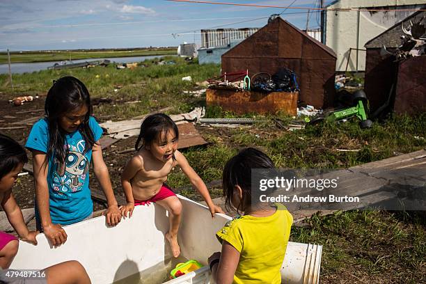 Yupik children play in a container filled with fresh water on July 3, 2015 in Newtok, Alaska. Newtok is one of several remote Alaskan villages that...