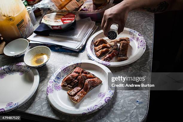 Jamin Tom sits down with his family for a meal of salmon that is half dried, then smoked and boiled on July 3, 2015 in Newtok, Alaska. Newtok is one...