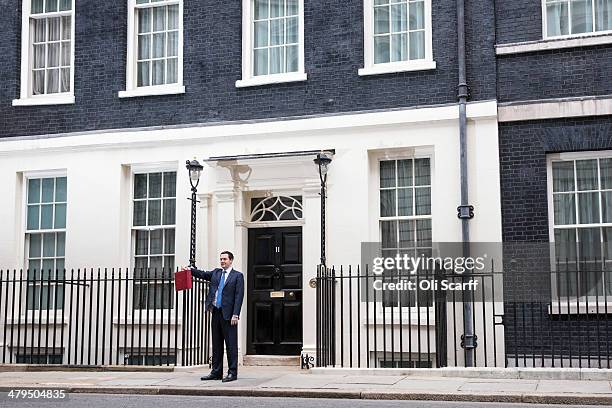 The Chancellor of the Exchequer George Osborne, holding the budget box, stands outside Number 11 Downing Street on March 19, 2014 in London, England....