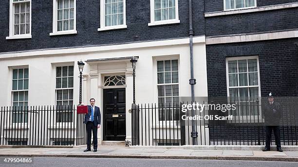 The Chancellor of the Exchequer George Osborne, holding the budget box, stands outside Number 11 Downing Street on March 19, 2014 in London, England....