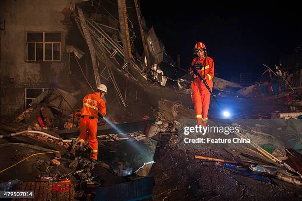 Chinese rescuers search for survivors in the debris after shoe factory collapse in Zhejiang province on July 04, 2015 in Wenling, China. More than 50...