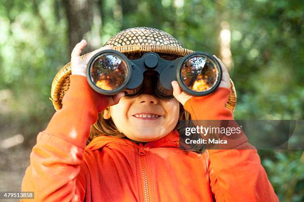 jeune fille à la recherche par le biais de jumelles - paire de jumelles photos et images de collection