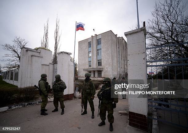 Russian soldiers stand at the gate after taking contol of the navy south headquarters base in Novoozerne on March 19, 2014. Russian forces seized...