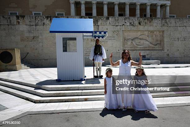 Greek bride Irene poses for pre-wedding photographs with her bridesmaids outside the Greek Parliament building. Irene declared to tourists as she...