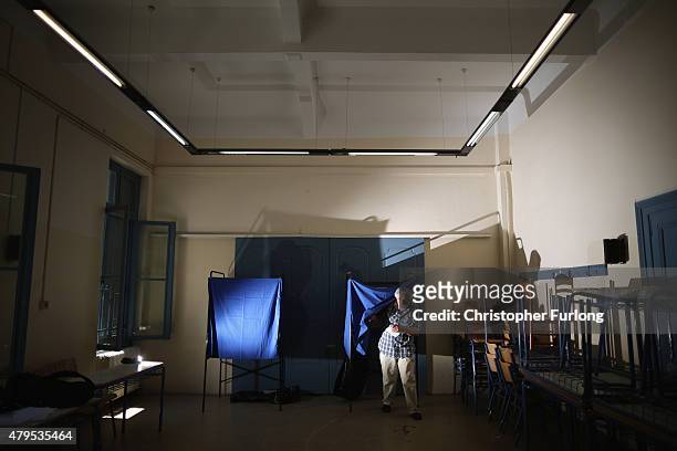 Man leaves the voting booth after marking his polling slip at a school near the Acropolis on July 5, 2015 in Athens, Greece. The people of Greece are...