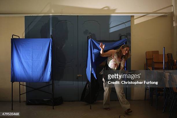 Woman leaves the voting booth after marking her polling slip at a school near the Acropolis on July 5, 2015 in Athens, Greece. The people of Greece...