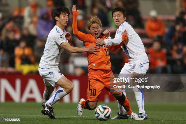 Genki Omae of Shimizu S-Pulse is tackled by Naoki Ishikawa and Jiro Kamata of Vegalta Sendai during the J.League Yamazaki Nabisco Cup match between...