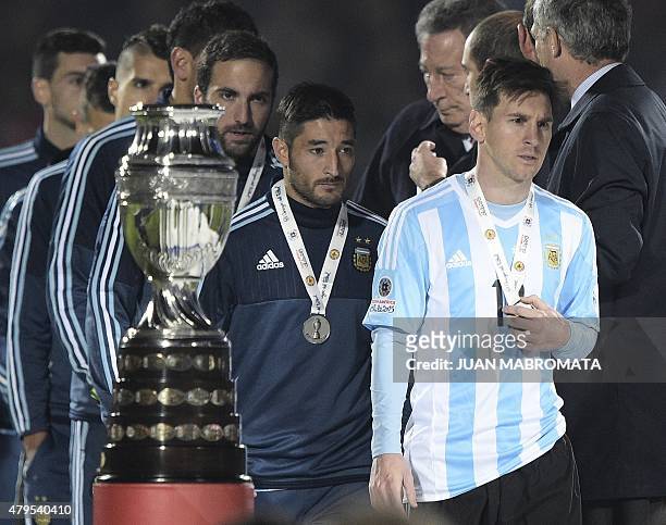 Argentina's forward Lionel Messi walks off the podium after receiving the second-place medal after losing to Chile in a penalty shootout at the end...
