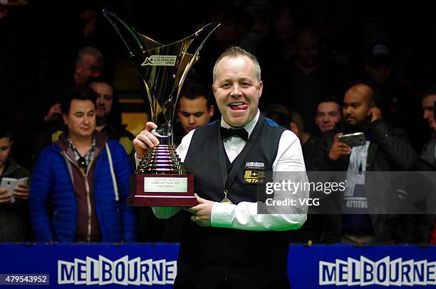 John Higgins of Scotland celebrates with the trophy after winning the final match against Martin Gould of England on day seven of 2015 Australian...